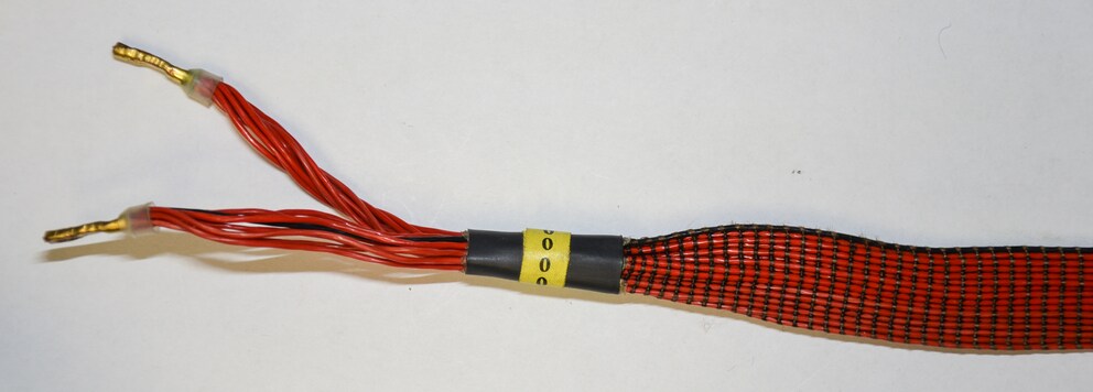 Flachbandkabel mit vielen parallel verlaufenden Litzen, abwechselnd für Plus und Minus, am Ende zusammengeführt.