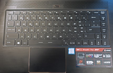 1.4 mm key travel and freely configurable RGB lighting. The image shows a Swiss keyboard.