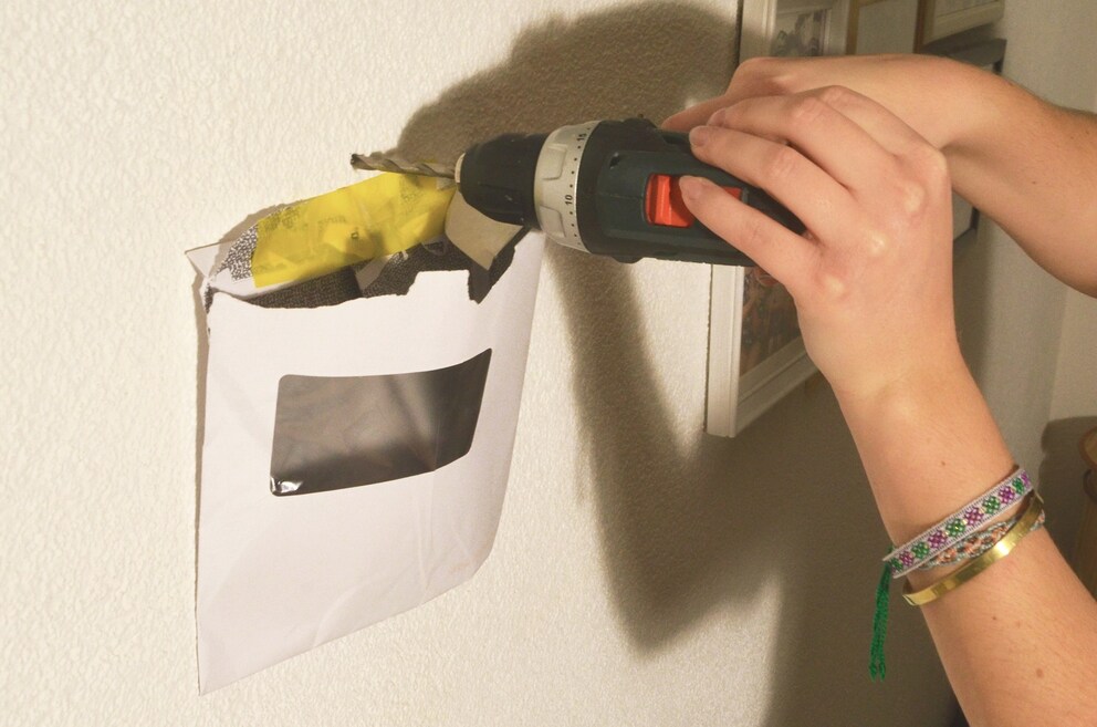 Beim Bohren fällt der ganz Staub in das geöffnete Couvert.