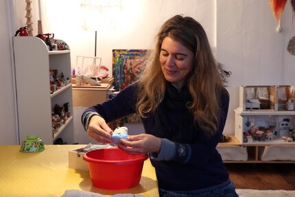 Brigit mischt die Modelliermasse an. Die rote Farbe der Wanne ist kein Zufall.