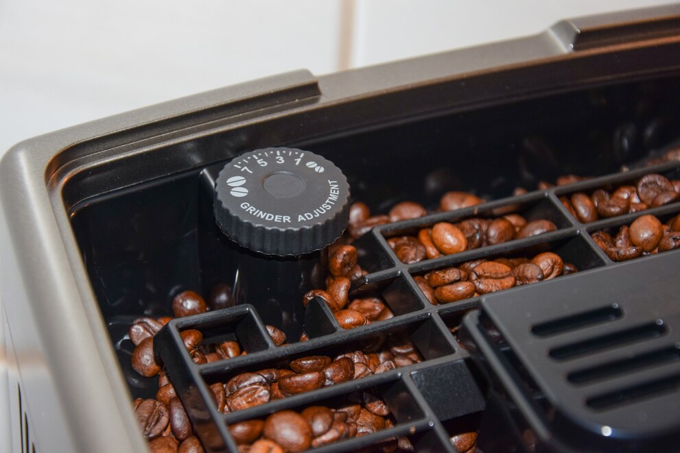 Im Bohnenbehälter befindet sich ein Rädchen zum Einstellen wie fein der Kaffee gemahlen wird.