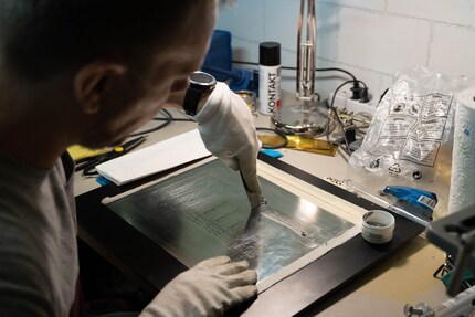Samuel streicht die Lötpaste auf die Leiterplatte.