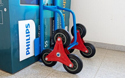 Auspacken, Räder und Unterlagsscheibe über Aufhängung ziehen und mit «Haarklammer» fixieren.