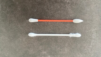 Ein herkömmliches Wattestäbchen (unten) im direkten Vergleich mit Lastswab (oben).
