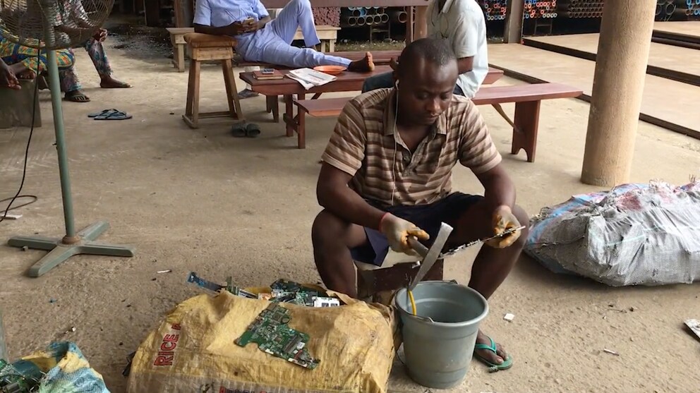 Auf dem Owode Onirin Market im nigerianischen Lagos bearbeitet ein Mann eine Leiterplatte. (Szene aus dem Dokumentarfilm Chinafrika.mobile von Daniel Kötter.)