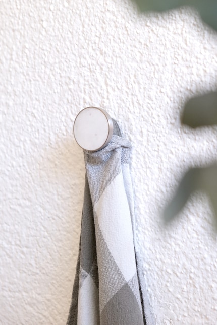 Ein Küchentuch veranschaulicht die Grösse des Wandhakens.