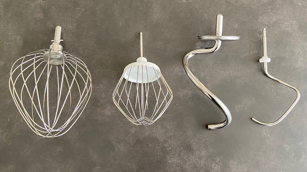 Der Ballonschneebesen und Knethaken meiner Bosch-Maschine (jeweils rechts) sind im direkten Vergleich Leichtgewichte: Der Knethaken von Kenwood wiegt mit 355 Gramm knapp siebenmal so viel wie der von Bosch (51 Gramm).