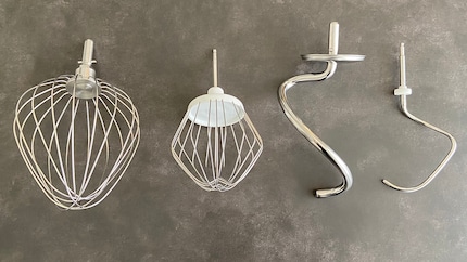 Der Ballonschneebesen und Knethaken meiner Bosch-Maschine (jeweils rechts) sind im direkten Vergleich Leichtgewichte: Der Knethaken von Kenwood wiegt mit 355 Gramm knapp siebenmal so viel wie der von Bosch (51 Gramm).