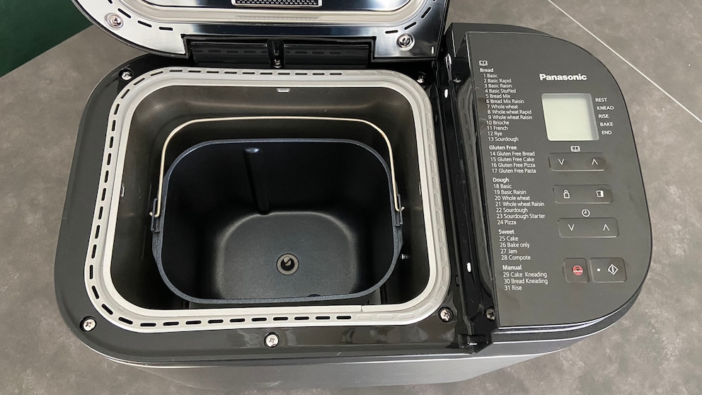 Im Inneren des Brotbackautomaten platzierst du die Backform. Den Knethaken auf den dafür vorgesehenen Befestigungsschaft (Mitte).