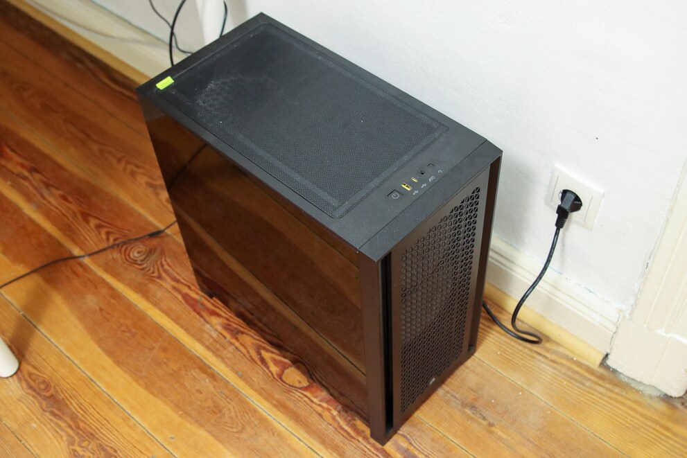 Unglamourös steht der fertige PC auf dem Boden neben dem Schreibtisch.