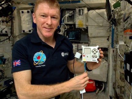 Der britische Astronaut Tim Peake hält einen Astro Pi auf der ISS in den Händen.