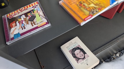 Ungleiche Nachbarinnen: Im offenen Bücherschrank prallen Welten aufeinander.
