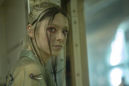 Jules Vaughn (Hunter Schafer) in rotem Lidschatten mit grafischen Akzenten.
