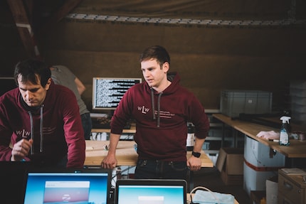 Tobias Schär in the room where old notebooks are refurbished and given a second life. On the left of the image: David Werder, Volunteer Refurbisher.