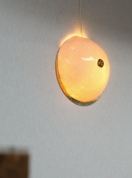 Manche sehen hier eine weisse Muschel, andere einen Busen mit einer goldenen Brustwarze.