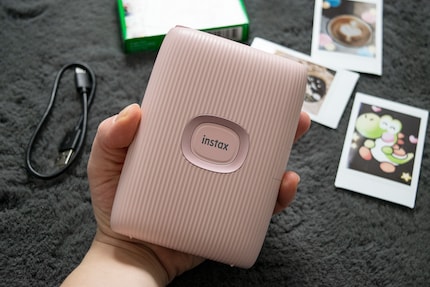 Die Instax passt gut in meine Hand und hat vorne einen grossen Einschaltknopf.