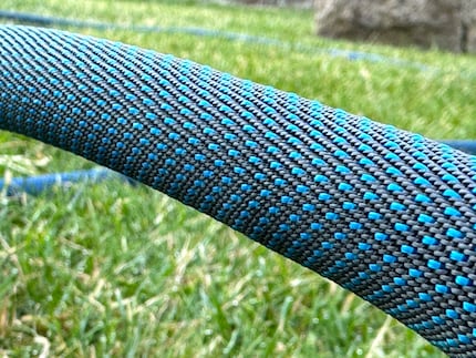 A resilient fabric protects the PVC hose inside.