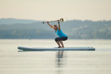 Das geht in die Beine! Kniebeugen auf dem SUP fördern Kraft und Balance.