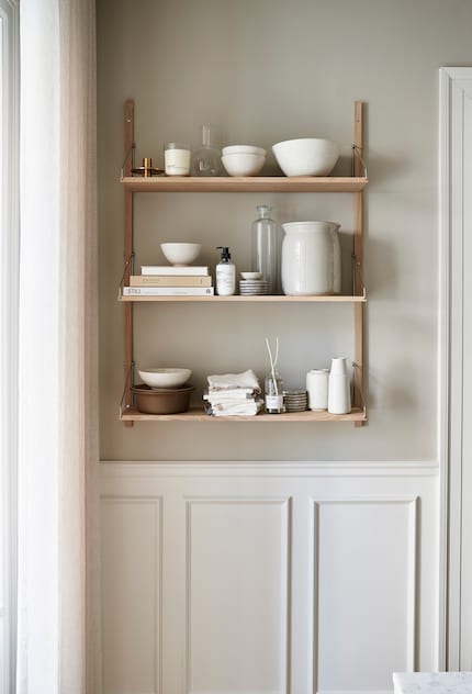 Dieses Regal nutzt den sonst verlorenen Platz an der Wand für eine Auswahl an Schalen und Büchern.