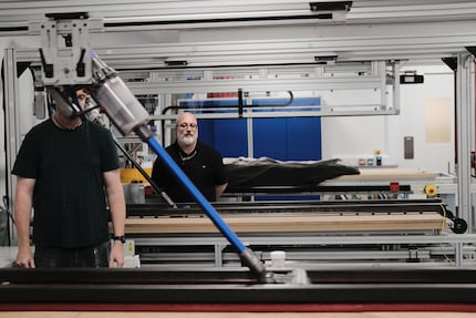 Mitarbeiter testen die Saugkraft auf normierten Teppichen.