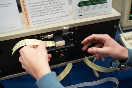 The punched perforated strip is clamped in the reader.