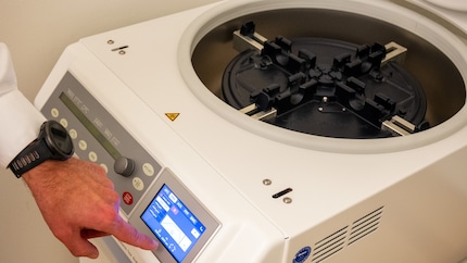 The doctor sets the centrifuge to five minutes.