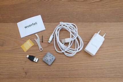 Im Lieferumfang des «Wuerfeli» ist entweder das Kabel enthalten oder der Adapter. Mit ihm kannst du den Sensor direkt per USB-Netzteil in einer Steckdose platzieren. Fürs Anbringen an Wand oder Möbeln gibt es Klebepunkte und einen Nagel.