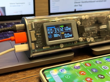 Zwei MacBooks und ein Smartphone werden gleichzeitig geladen.