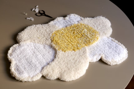 Nachdem der Teppich vom Rahmen gelöst wird, kann er zugeschnitten werden.