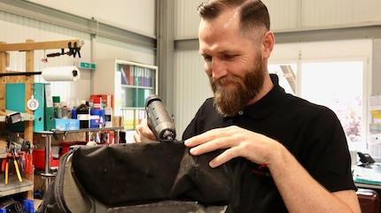 Konzentriert und mit handwerklichem Geschick: Die Tasche wird wieder fit gemacht.