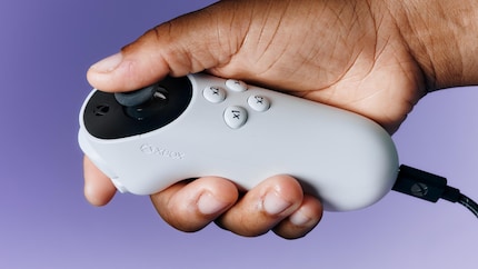 Der Xbox Adaptive Joystick in einer Hand mit fünf Fingern.