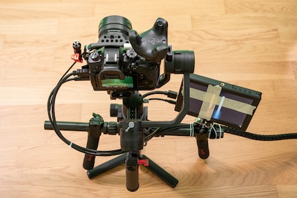 Kamera mit Gimbal und montiertem Tracker. Die Bildschirmausgabe ist viergeteilt. Das Klebeband lenkt die Aufmerksamkeit auf den Teil unten rechts, wo alles zusammengefügt wird.
