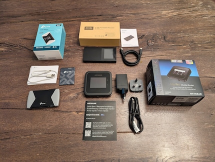 Die drei Modelle mit allem Zubehör. Netgear liefert als einziger Hersteller ein Ladegerät mit.