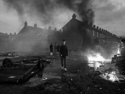 Jugendliche legen ein Feuer in der heruntergekommenen Roden Street in Belfast.