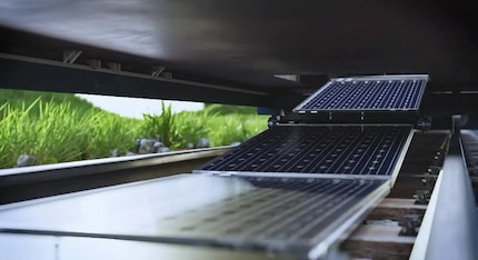 Die Solarmodule werden vom Zug automatisch auf dem Gleisbett ausgerollt.