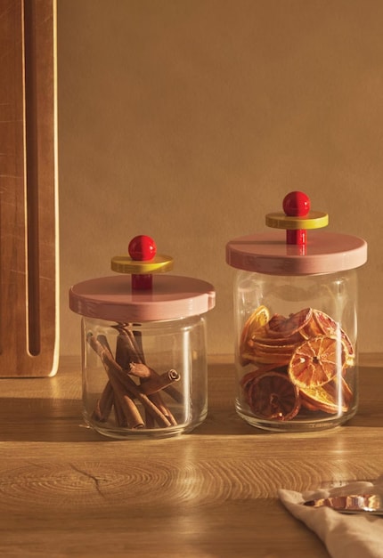 Die Twergi Vorratsdose vereint zeitloses Design mit farbenfroher Eleganz – inspiriert von Ettore Sottsass' ikonischem Stil und gefertigt aus Glas und FSC-zertifiziertem Lindenholz.
