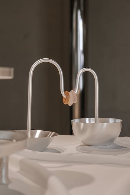 Die zwei Schalen des Aperitivo-Sets sind durch eine Metallstange mit drei verschiebbaren Quarzsteinen verbunden.