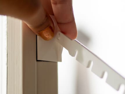 Schritt 2: Die selbstklebende Platte mitsamt Bügel am Fenster befestigen.
