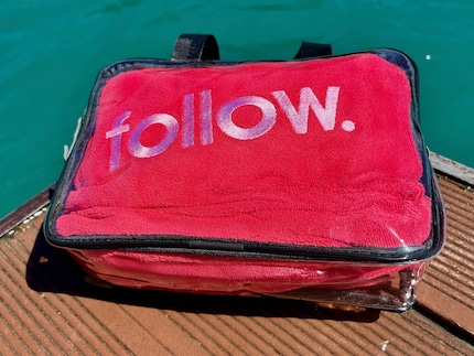 Praktisch für den Transport: Der Surf-Poncho wird in einer Kunststofftasche geliefert.